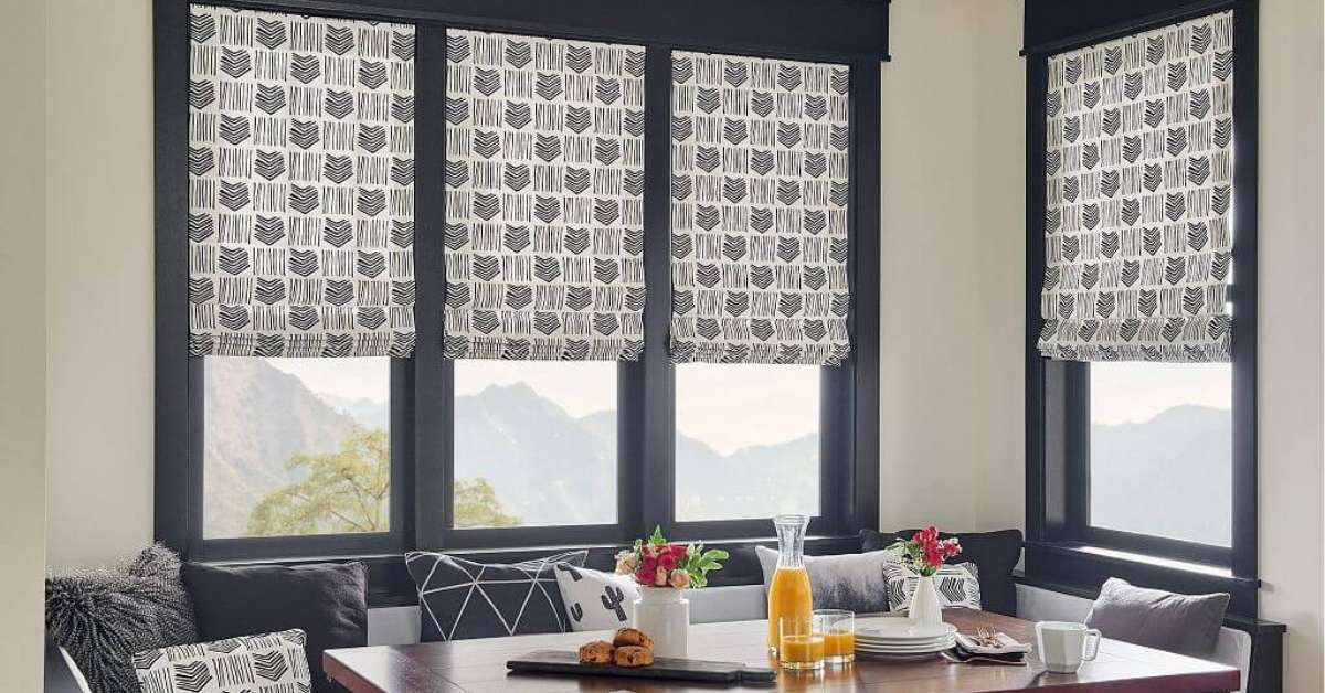 Patterned Graber Roman Shades in a Dining Room with a table.